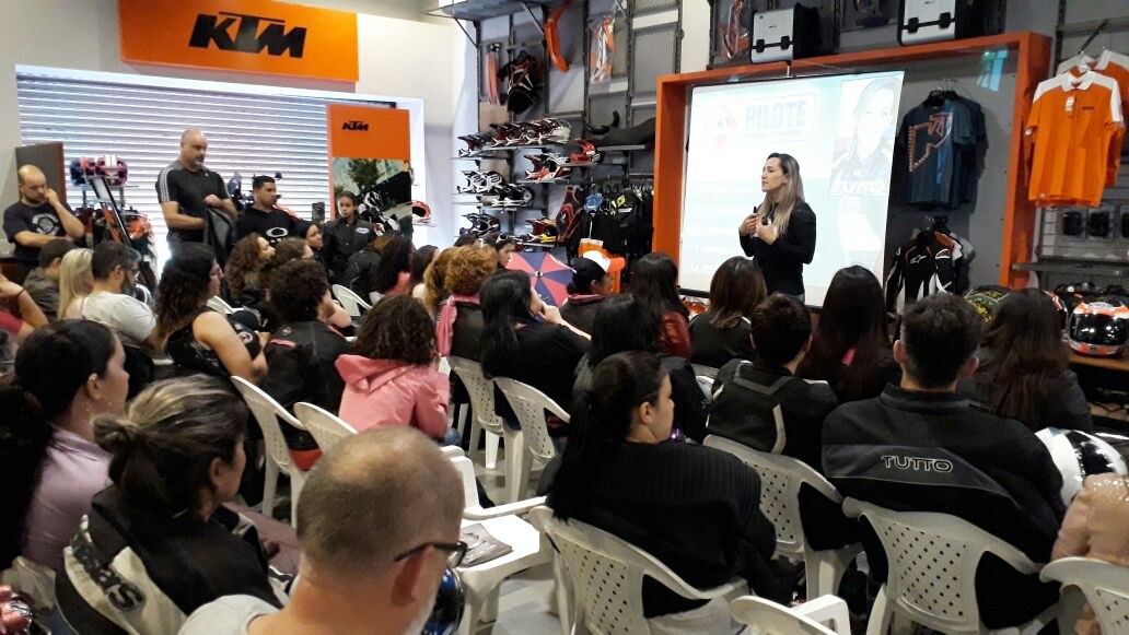 Márcia Reis a falar para uma sala cheia numa concessionária de motos